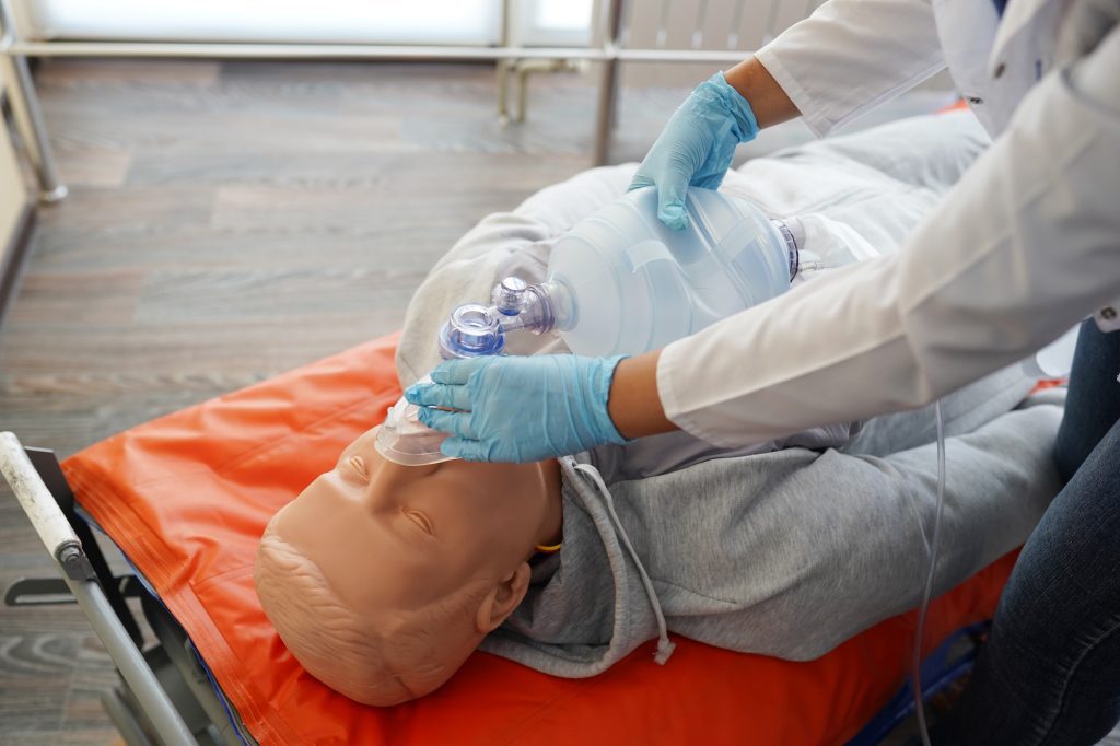 Nursing students are practicing how to provide oxygen administration to the patient by a doll