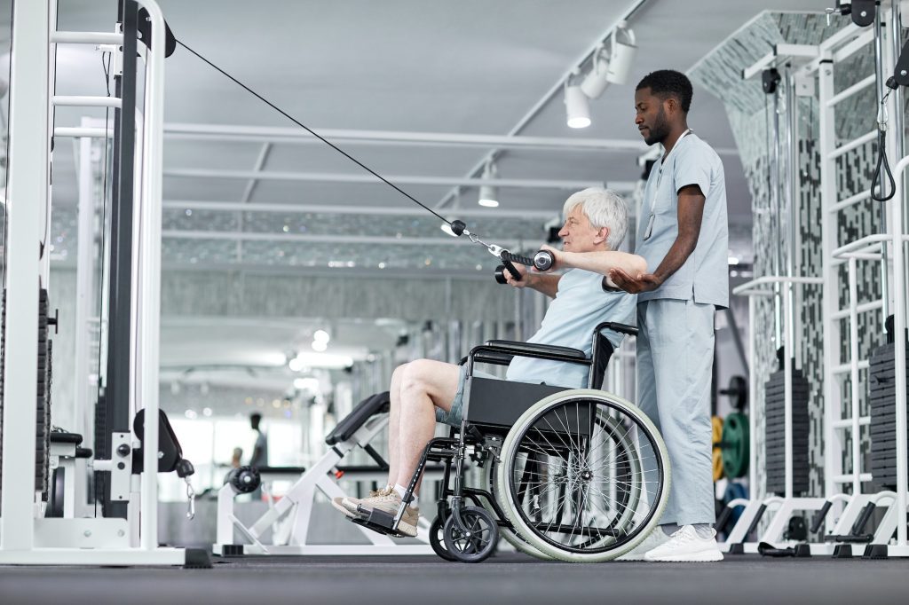 Rehabilitation Therapist Assisting Senior Patient in Wheelchair