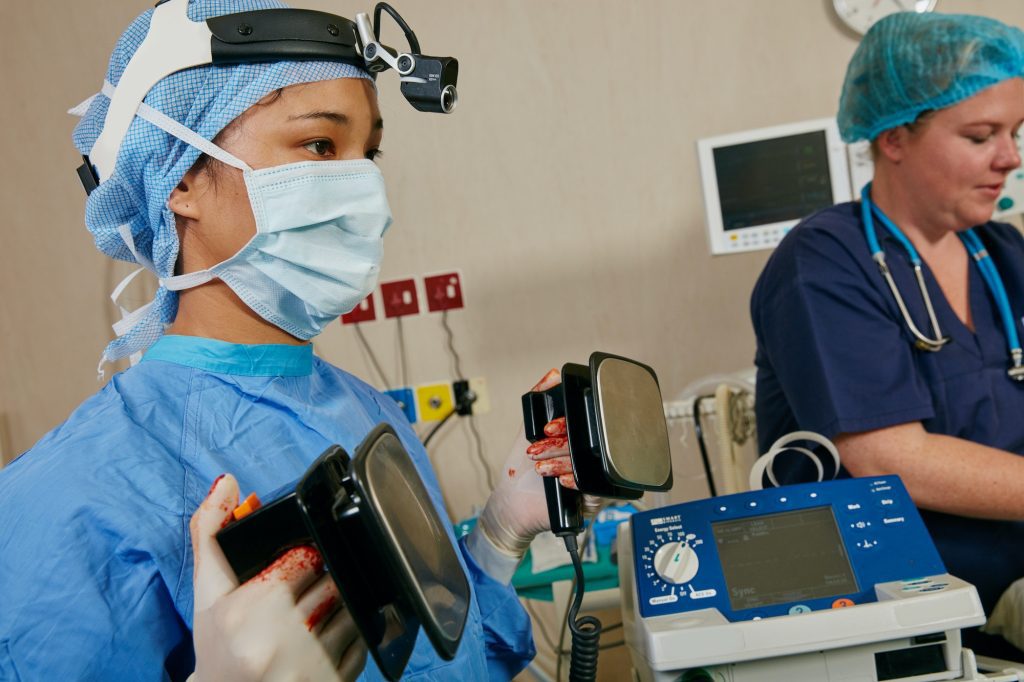 Shot of a surgeon using a defibrillator on a patient during surgery