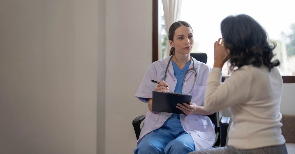 Asian female patient undergoing health check up while female doctor uses stethoscope to check heart