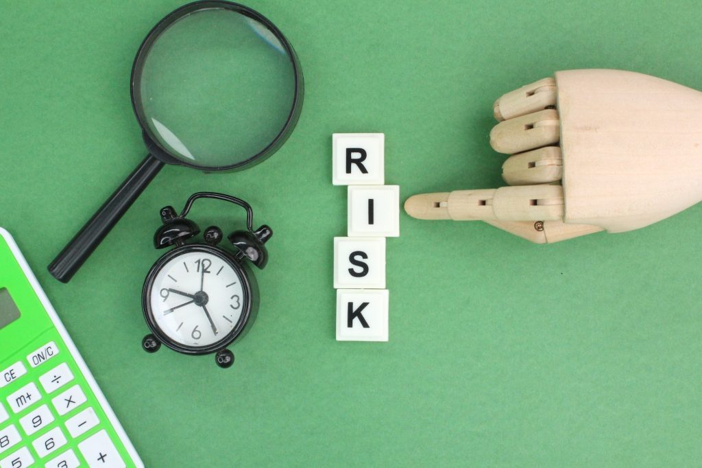 calculator, clock and magnifying glass with the word risk.