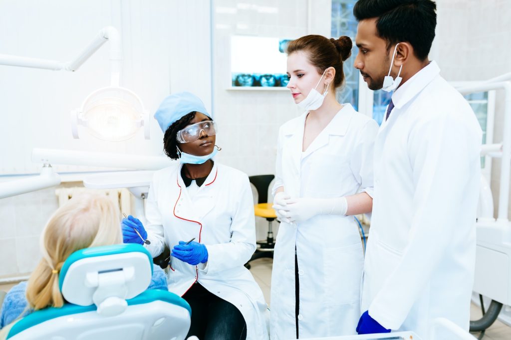 Multiracial dental team with patient in dental clinic. Dental health concept