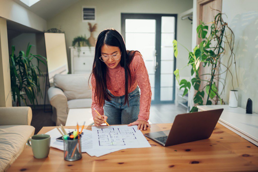 Vietnamese Asian woman using a laptop in her home office