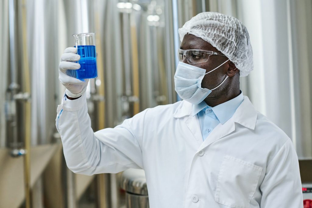 Engineer examining chemical material in glass