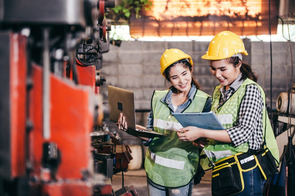 Two female engineers discussing project at a factory