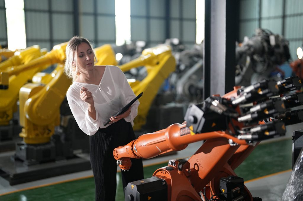 Worker at machine in factory, Metal industry worker at factory.