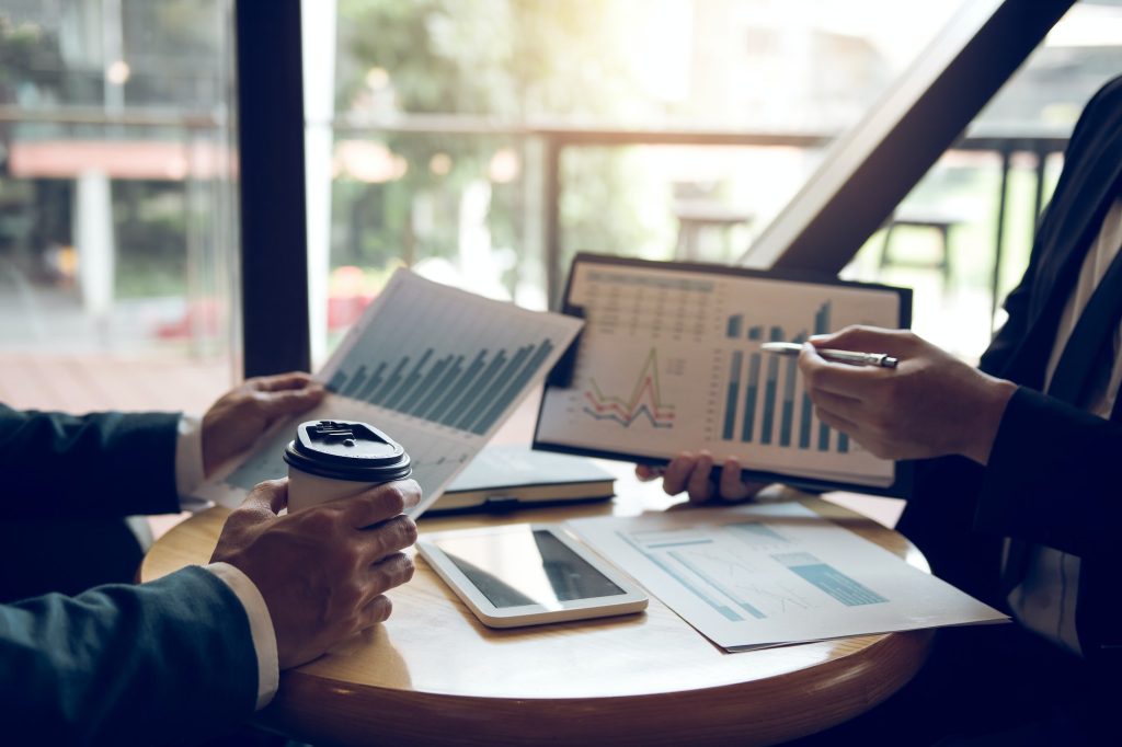 Businessmen pointed out the company performance chart on the table during a strategy