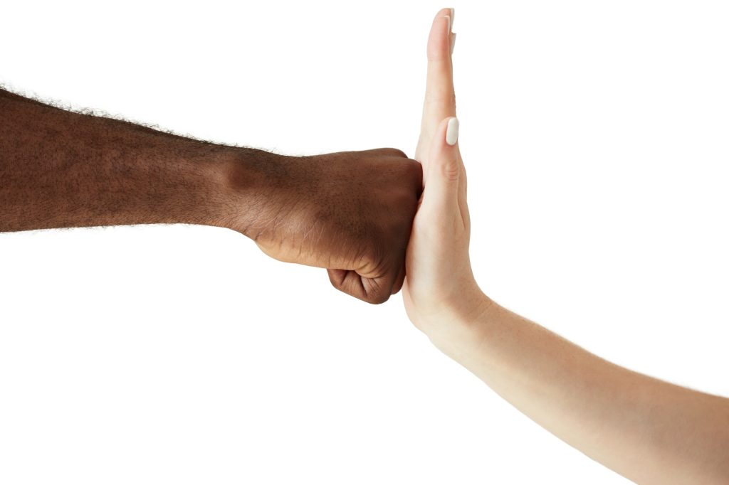 Close up of two people of different ethnicites and cultures holding hands in handshake showing respe