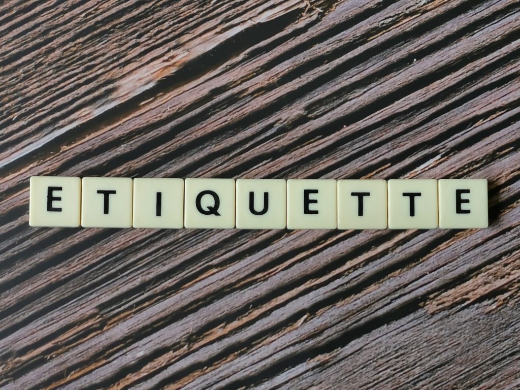 ETIQUETTE word made from square letter tiles on wooden background.