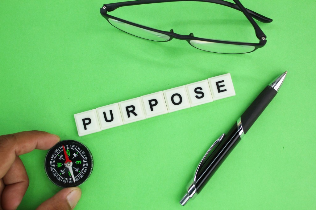 glasses, pen and compass with the word purpose.