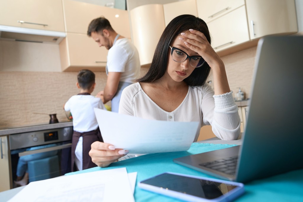 Stressed lady dealing with working documents at home