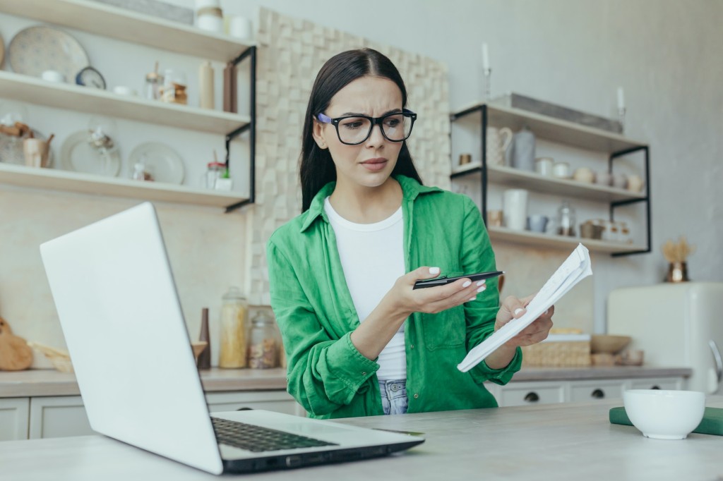 Worried woman studying online with laptop kitchen beautiful student not understanding information