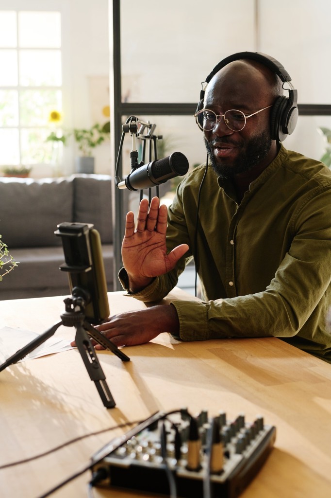 Young black man in casualwear waving hand to his online audience