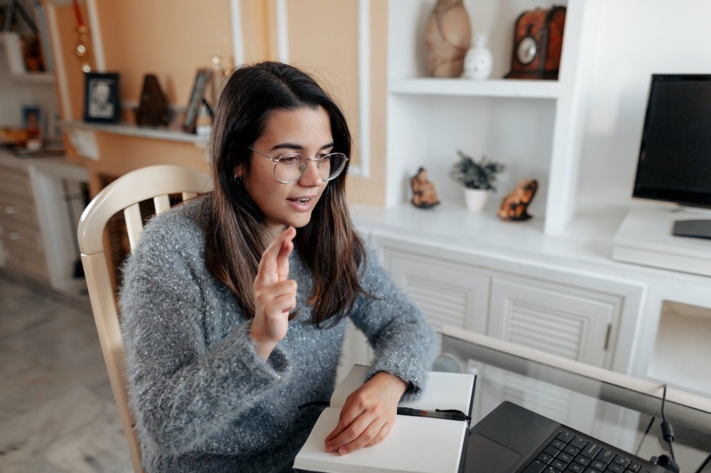 Young deaf woman having a non verbal conversation in online video call