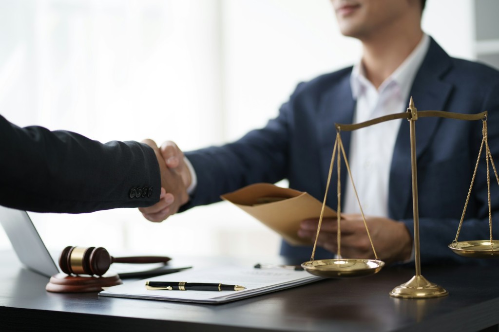 Handshake after Lawyer providing legal consult business dispute service to the man at the office.