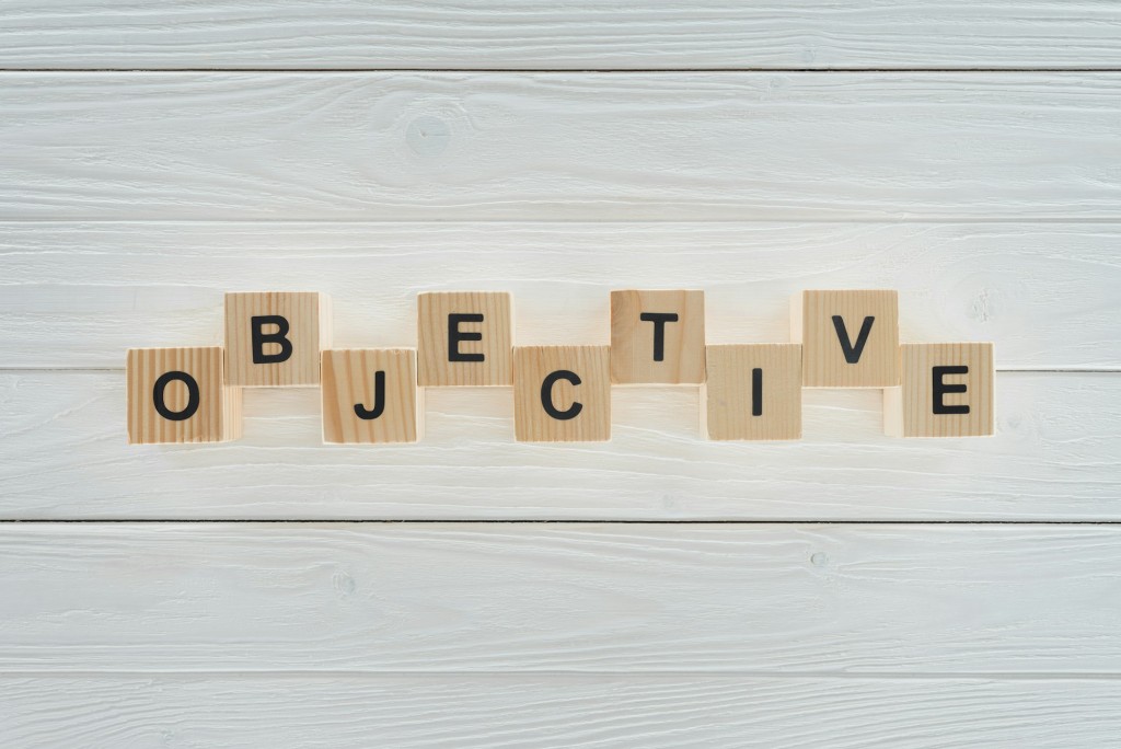 top view of objective word made of blocks on white wooden surface