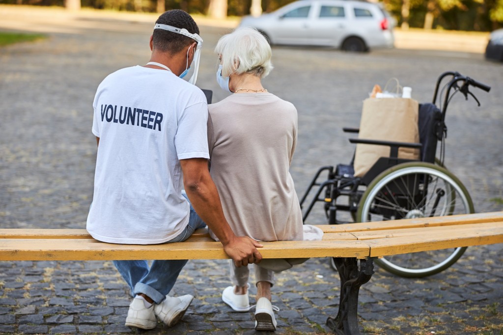 Volunteer spending time with elderly woman outdoors