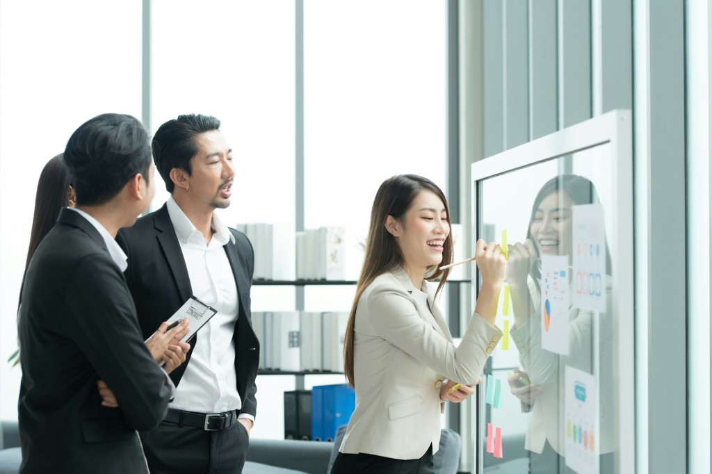 Young entrepreneurs in Asia Organize meetings to brainstorm and review information on glass board