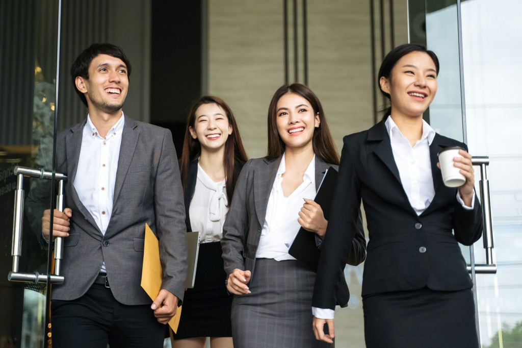 Asian business people walking to go out office building