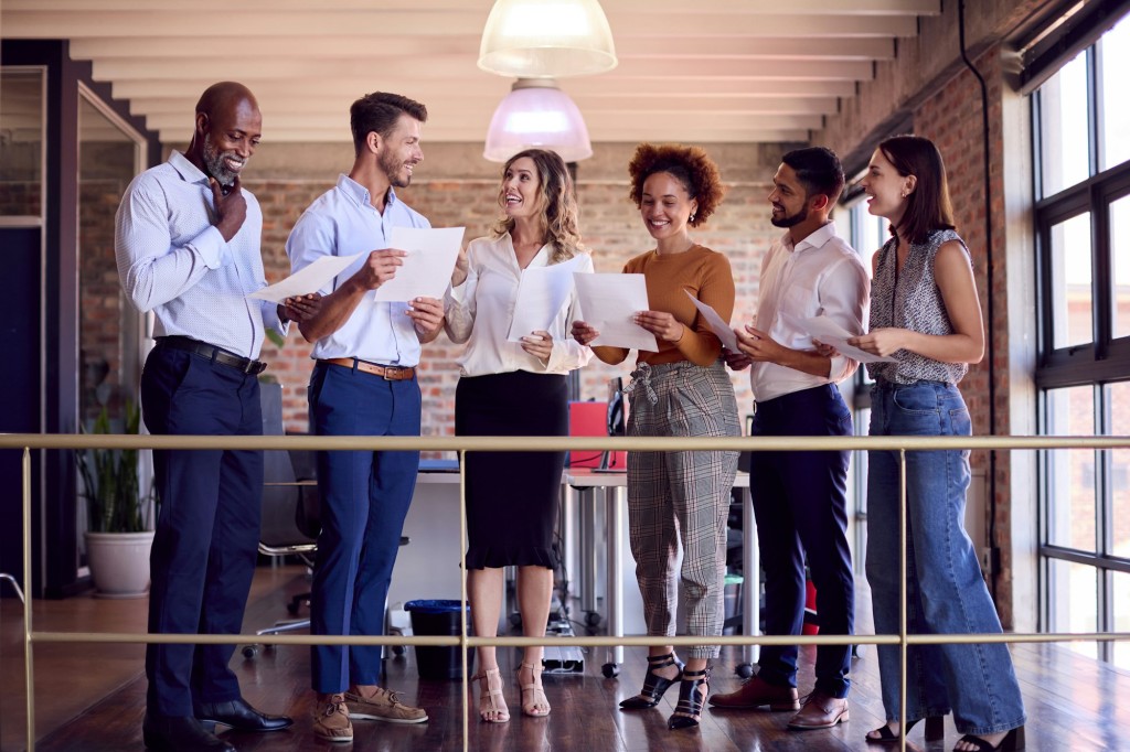 Businesswoman Leading Team Meeting In Busy Multi-Cultural Office