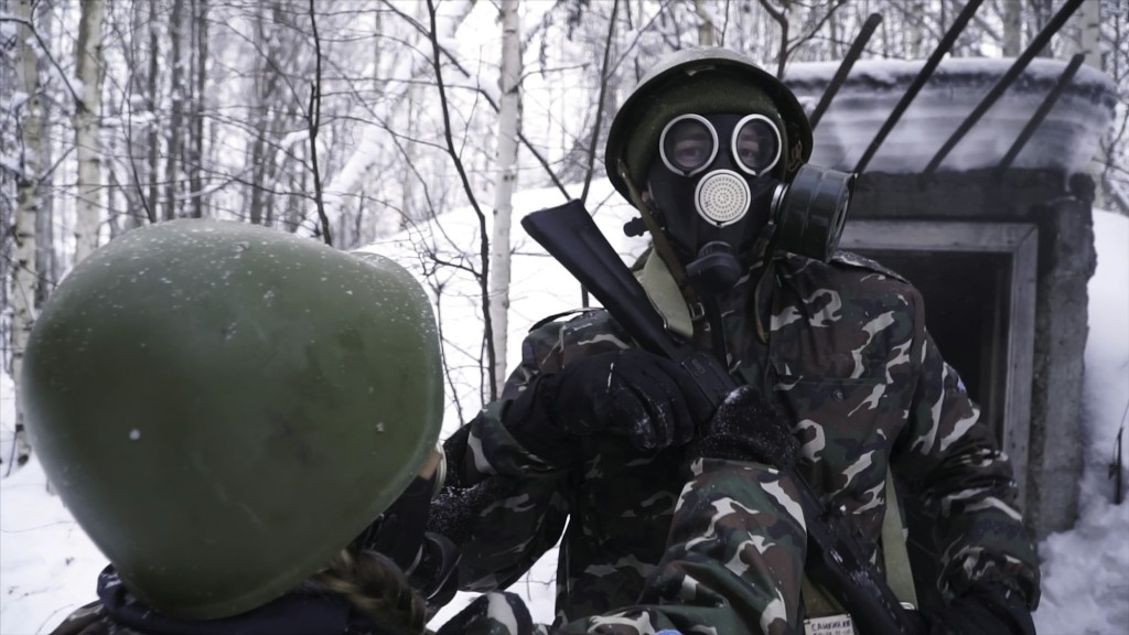 Man in uniform wearing a gas mask in the winter forest. portrait of a young soldier wearing a gas