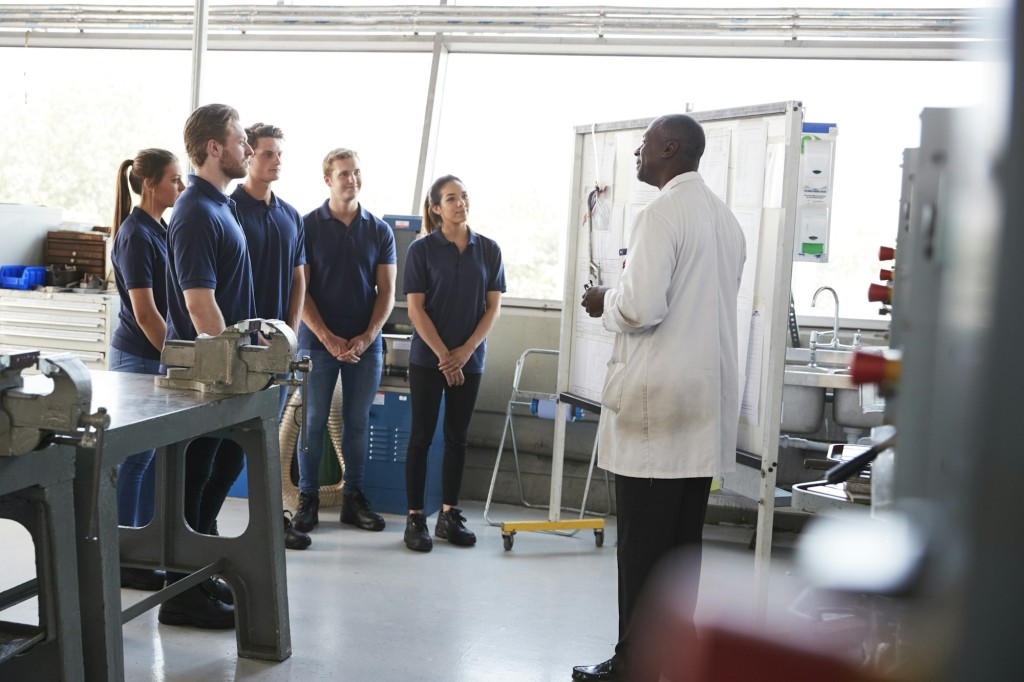 Engineering apprentices standing at a training presentation